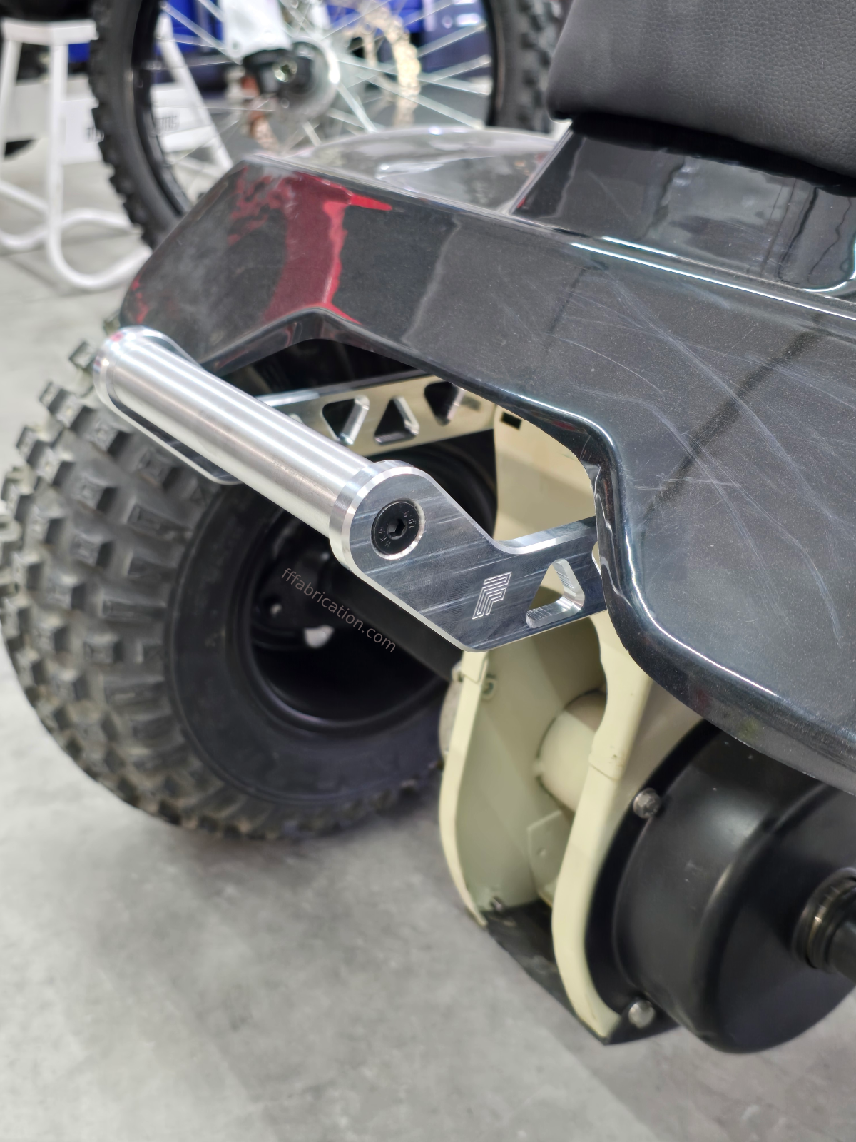 Close-up of a scooter's undercarriage with visible suspension and wheel.