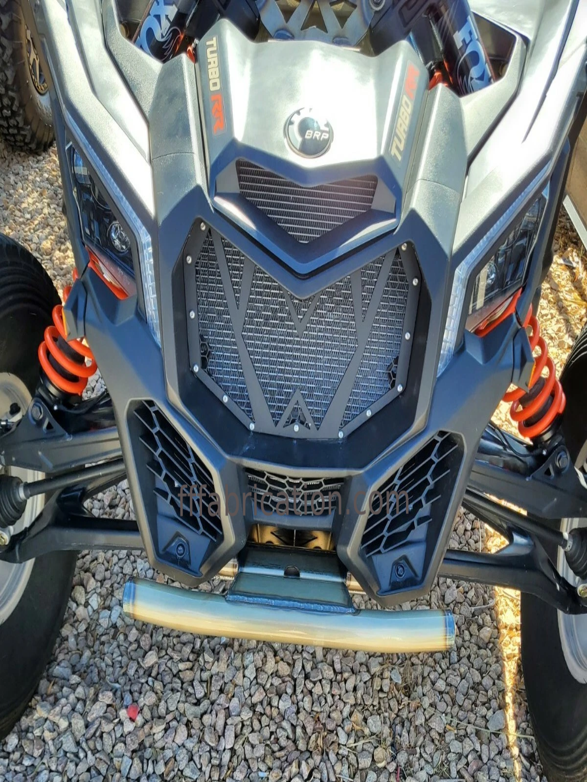 Close-up of a blue and silver off-road vehicle on a gravel surface