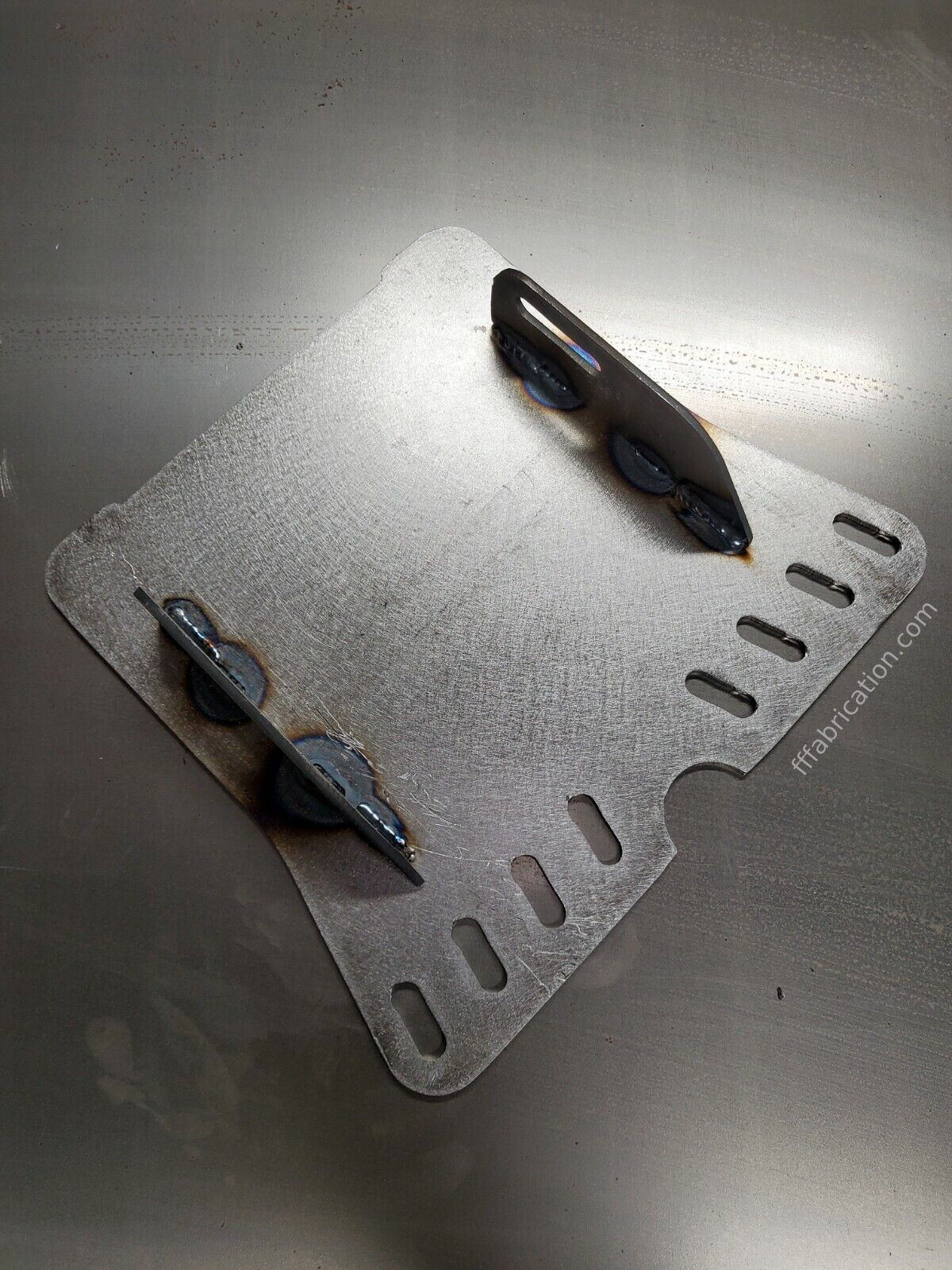 Metallic tool holder with three tools on a reflective surface