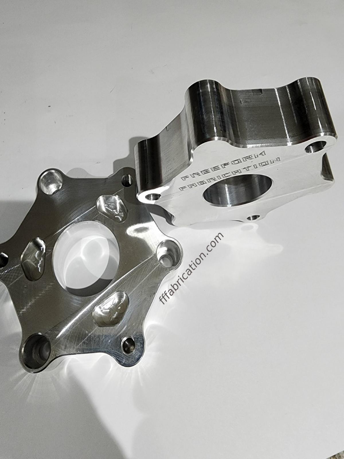 Metal mechanical component on a white background with 'ffabrication.com' text.