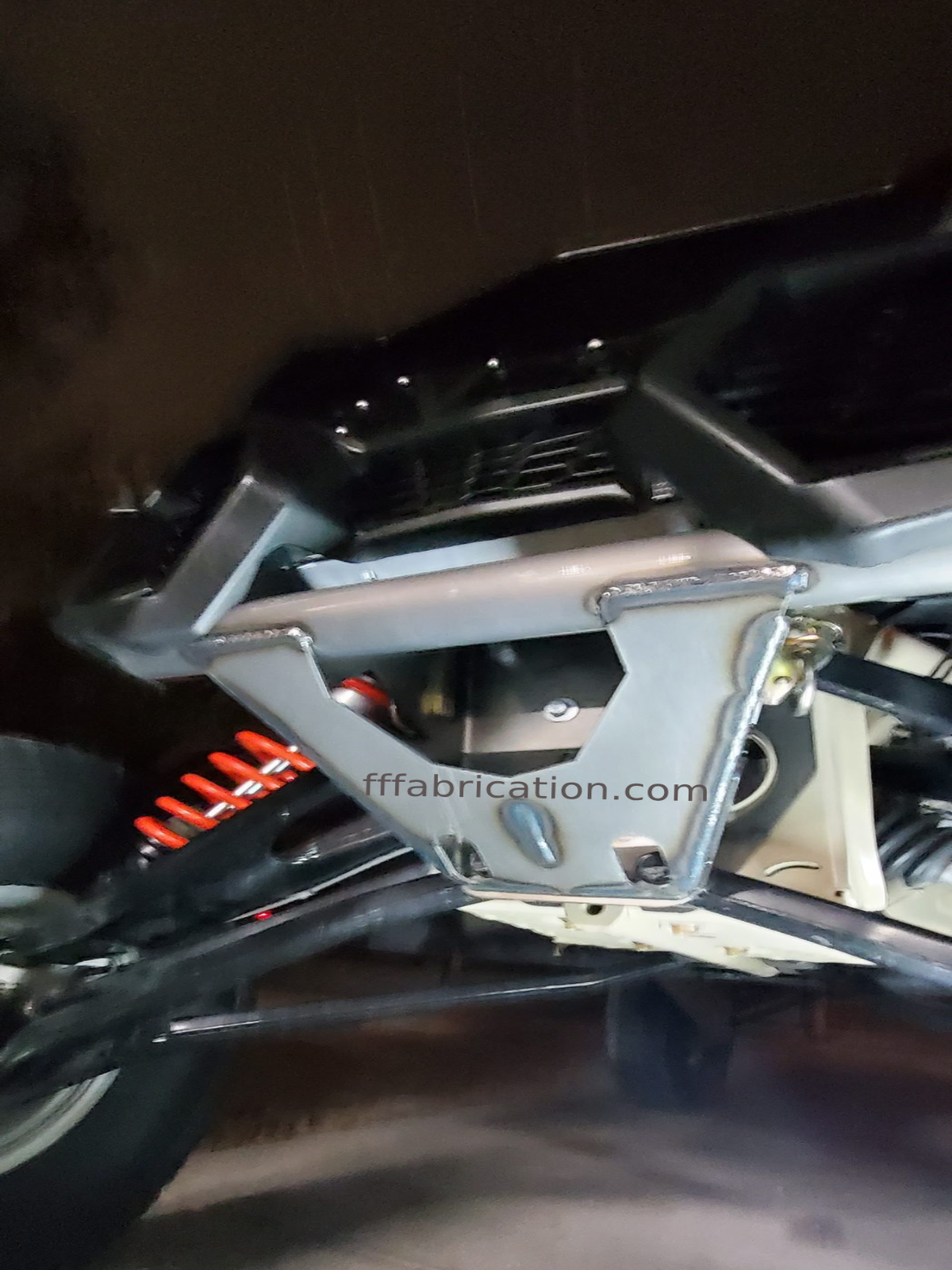 Close-up of a metal frame or bracket on a vehicle, with 'fffabrication.com' branding.
