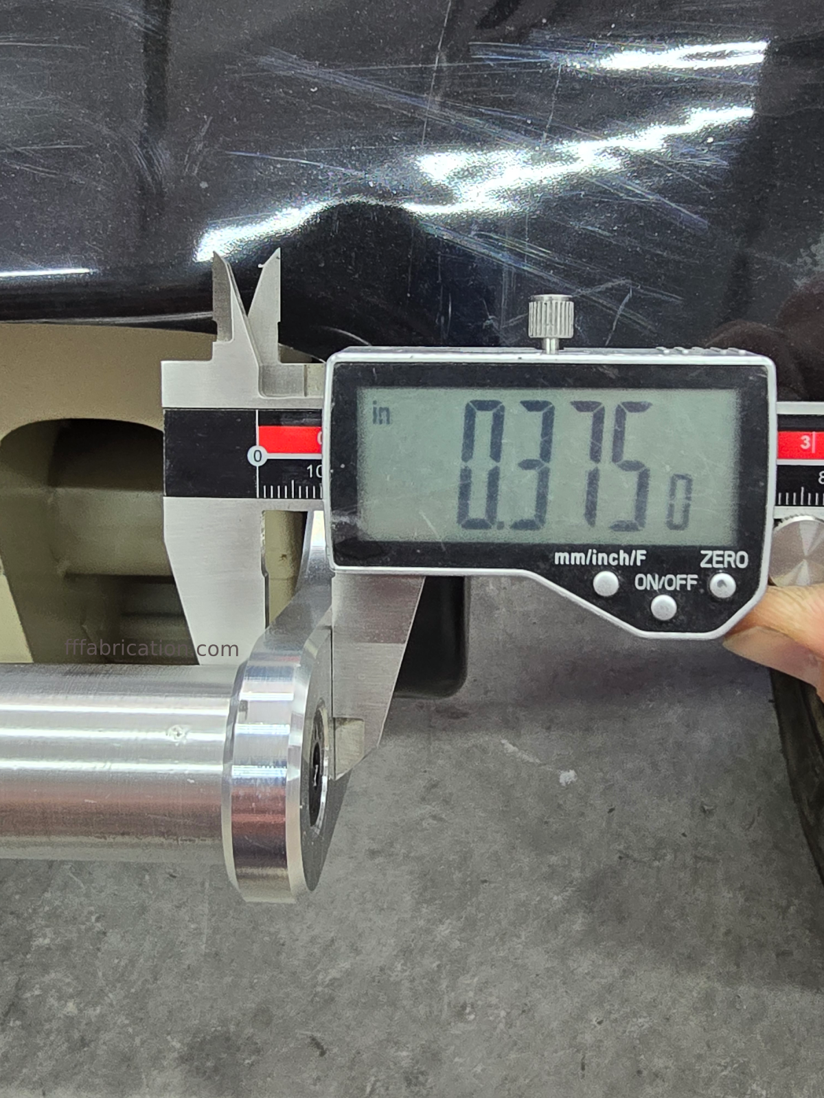Digital caliper measuring a metal rod with a digital display showing 0.375.