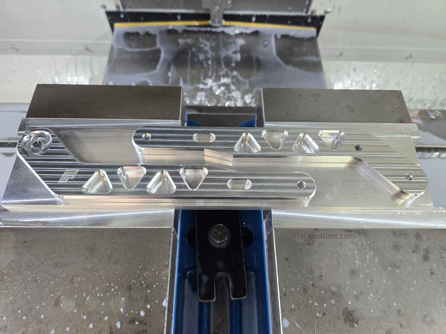 Metal cutting machine with a close-up of a metal component on a metallic surface.