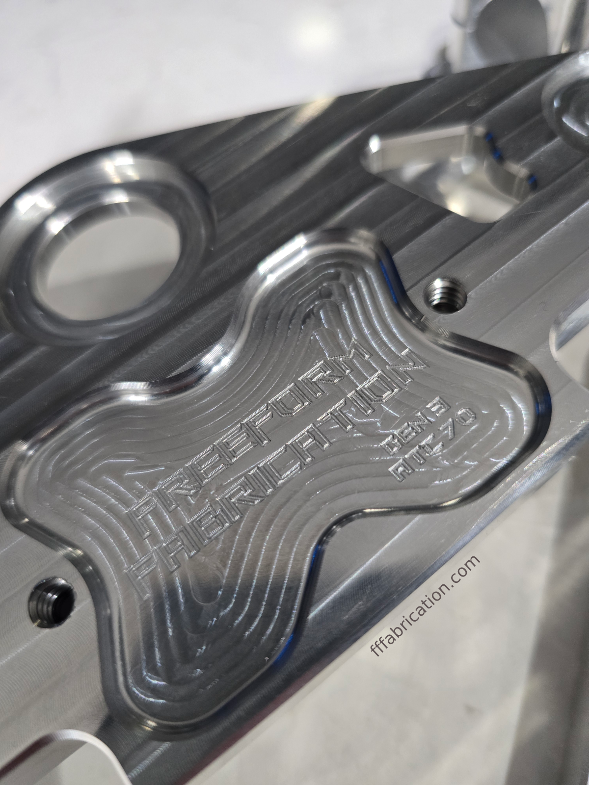 Metallic component with engraved text on a white background