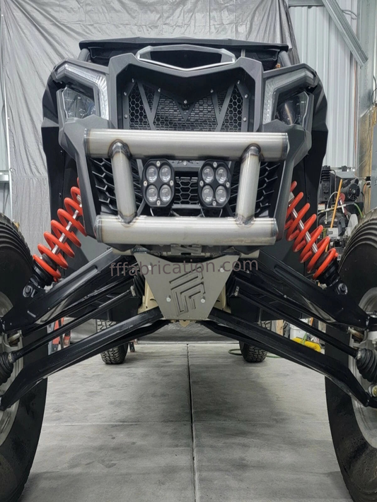 Front view of a vehicle with off-road suspension and lights in a warehouse setting.