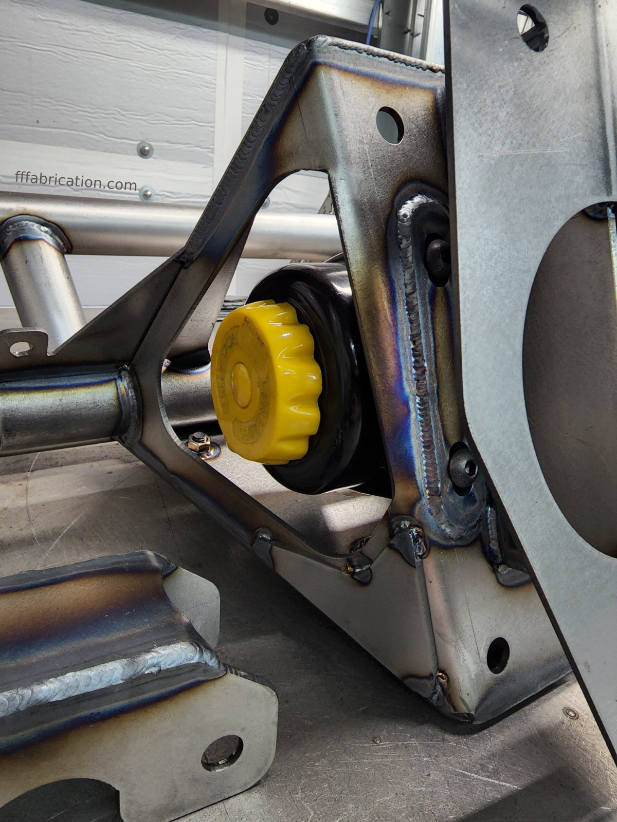 Close-up of a metal mechanical component with a yellow knob