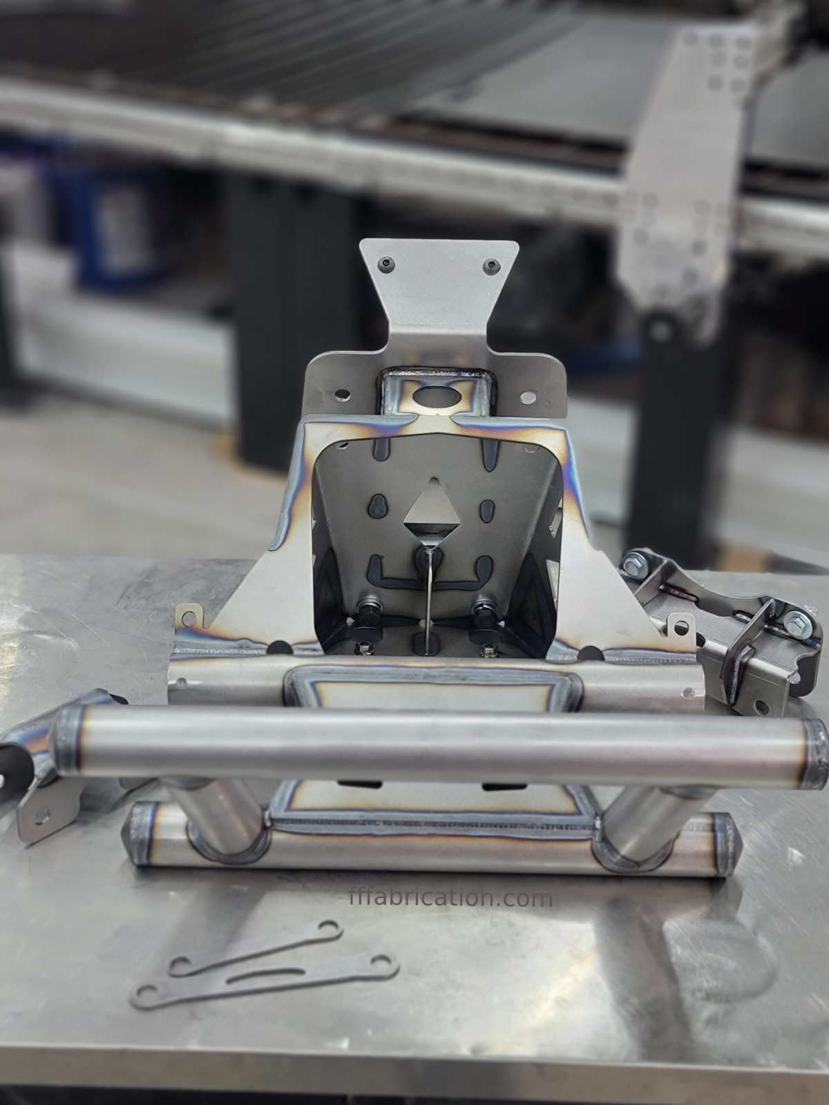 Metal mechanical component on a workshop table with blurred background