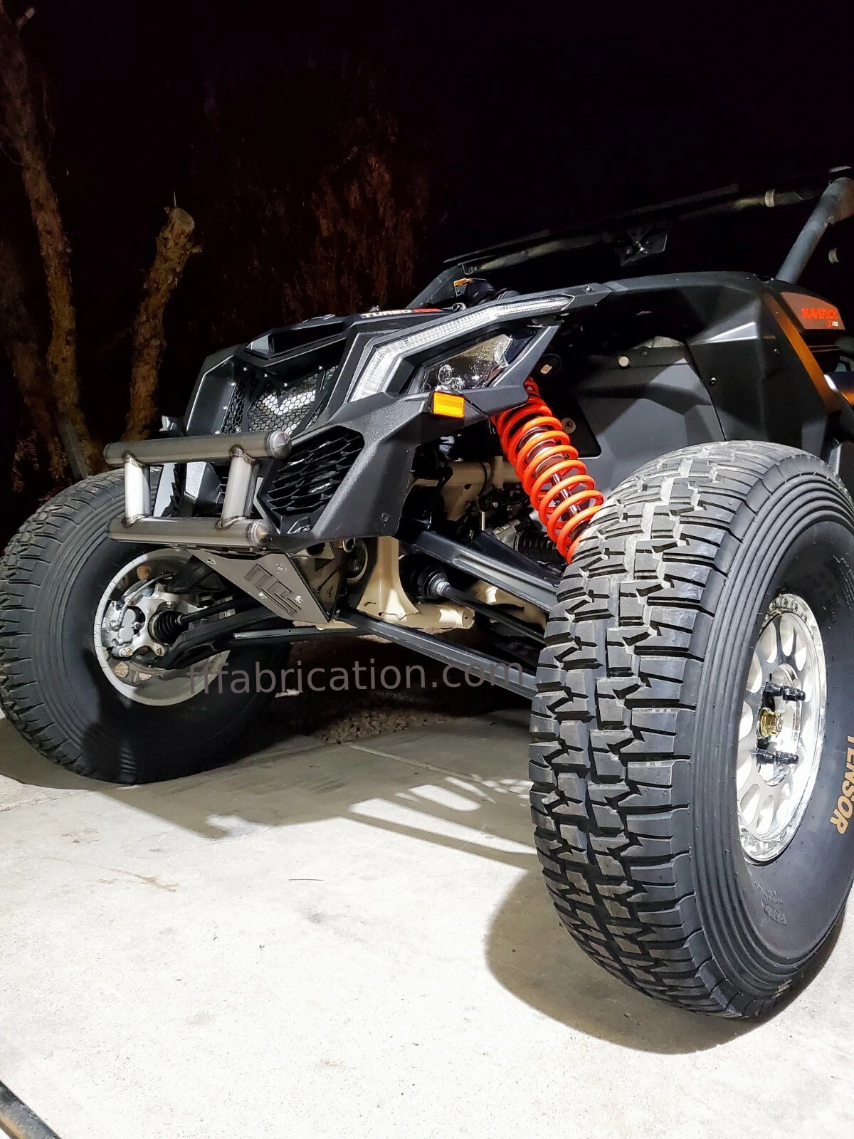 Close-up of a rugged off-road vehicle with large tires on a dark background