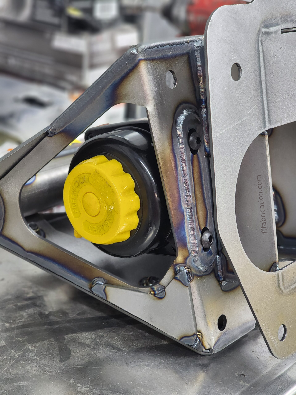 Close-up of a metal device with a yellow component on a blurred background