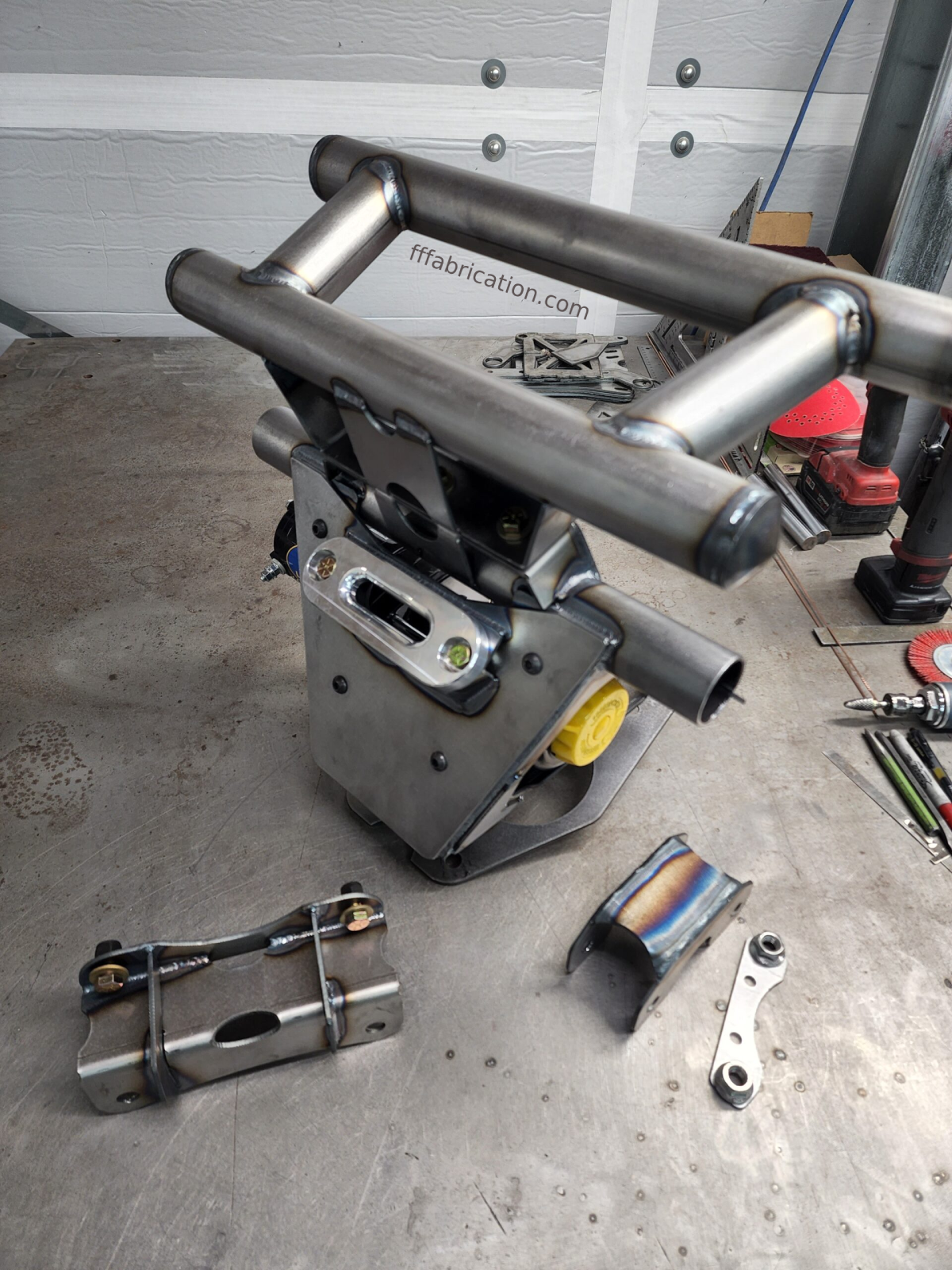 Metal mechanical component on a concrete floor with tools and parts in the background