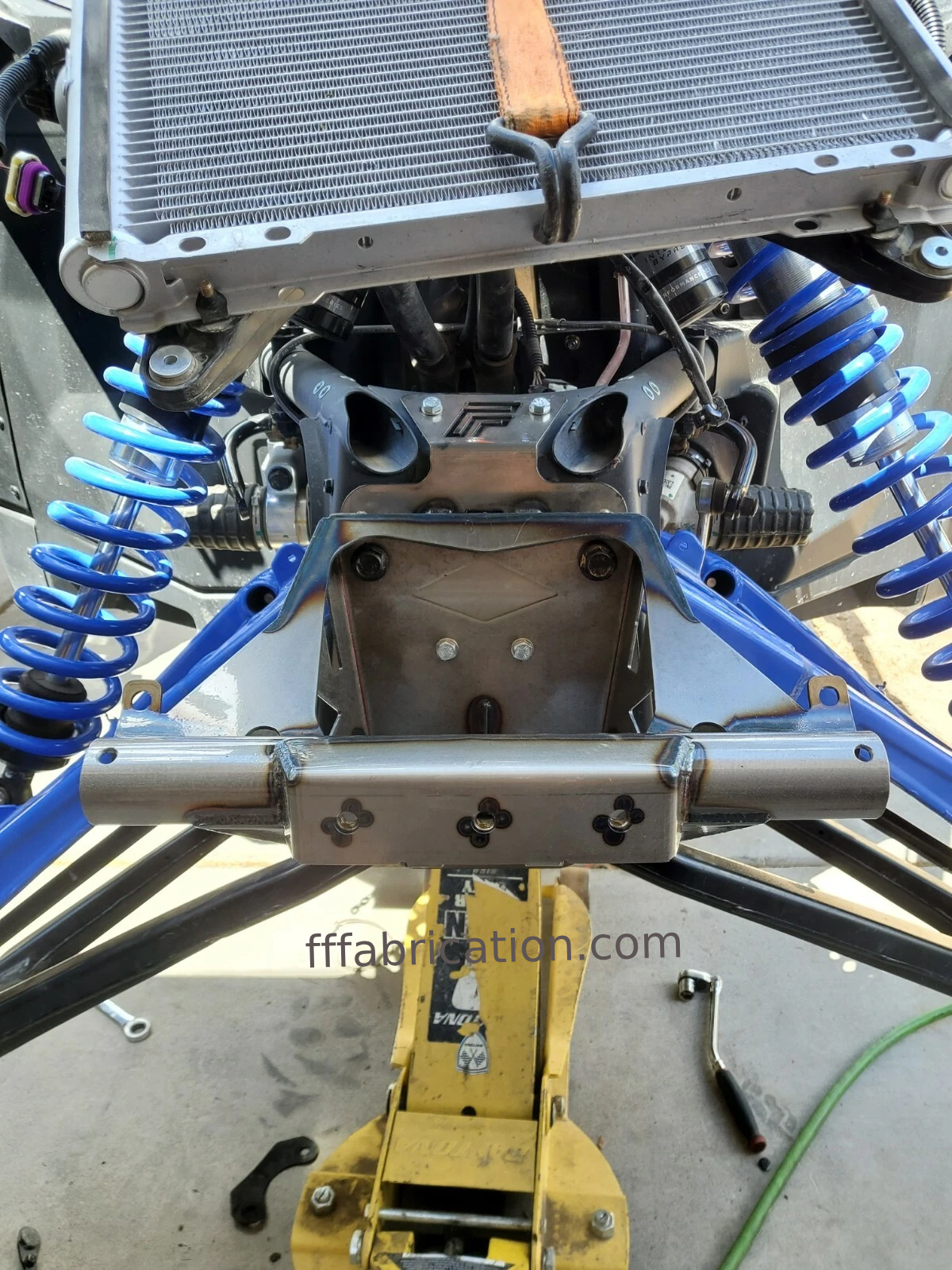 Close-up of a mechanical component with springs and a radiator, branded 'fffabrication.com'.