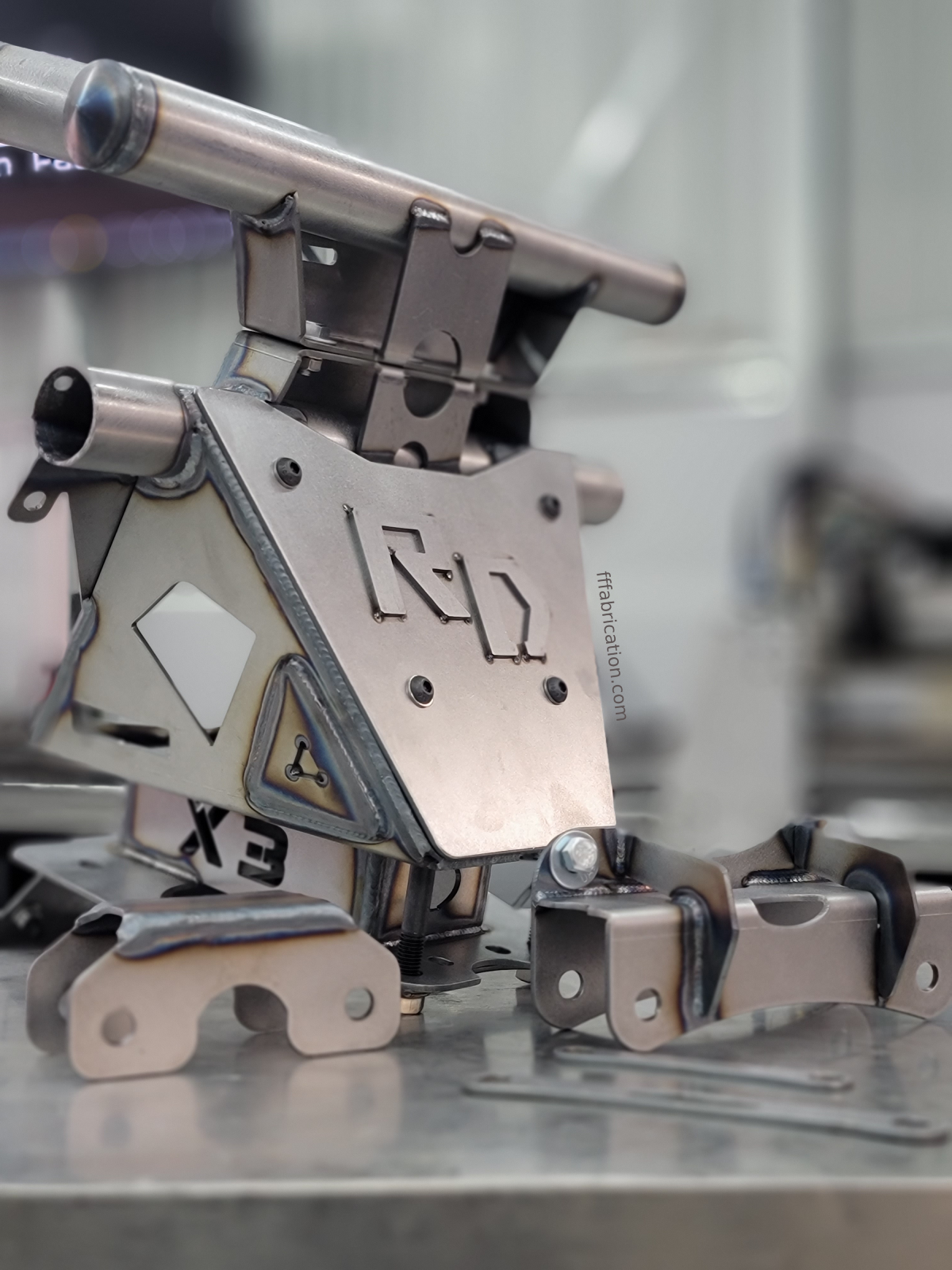 Metal mechanical device with 'ELY' branding on a reflective surface