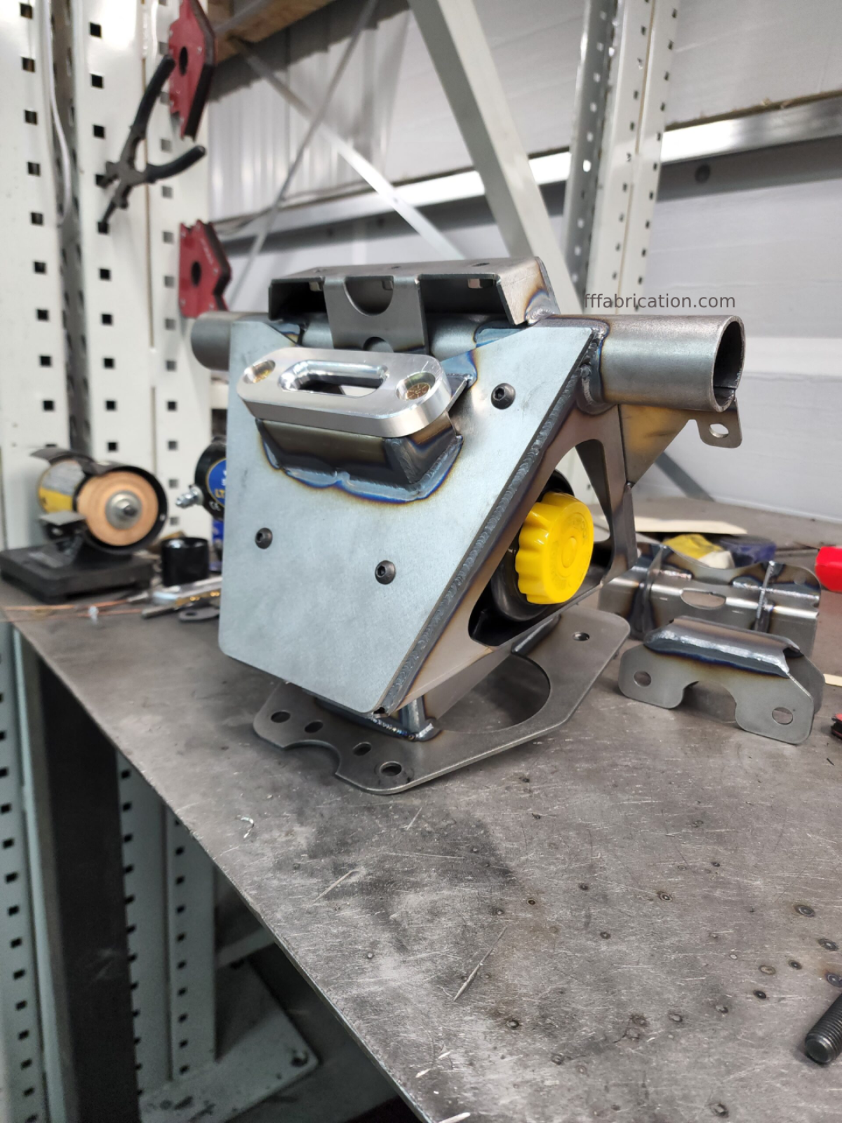 Metal mechanical component on a workbench with tools in the background