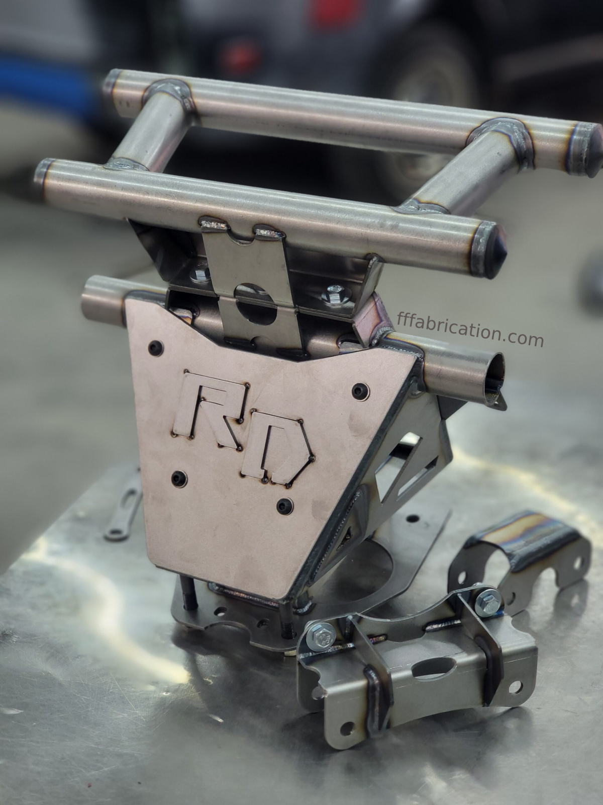 Metal fabrication component with 'R D' branding on a metallic surface