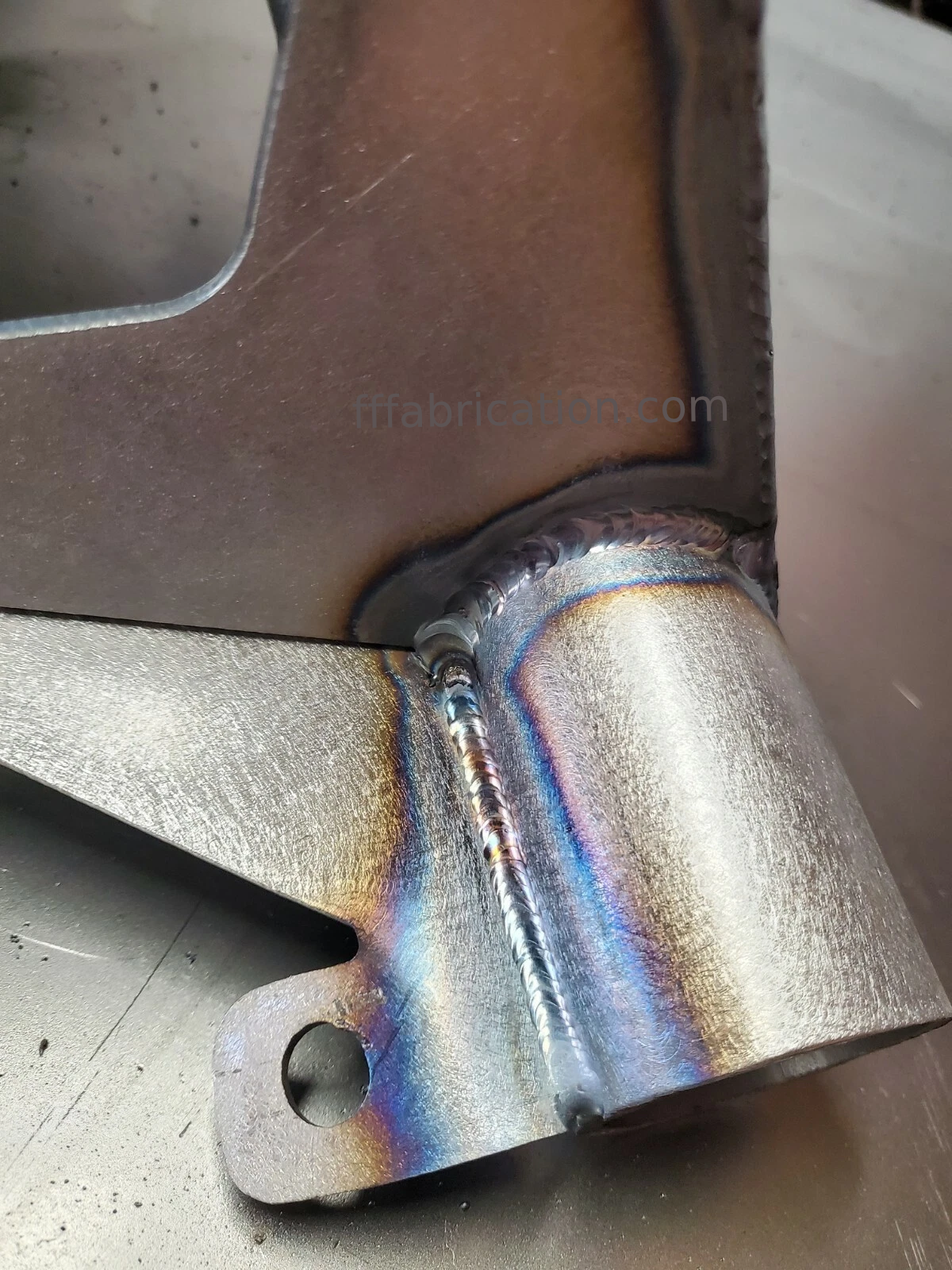 Metal exhaust pipe with rainbow coloration on a metallic background