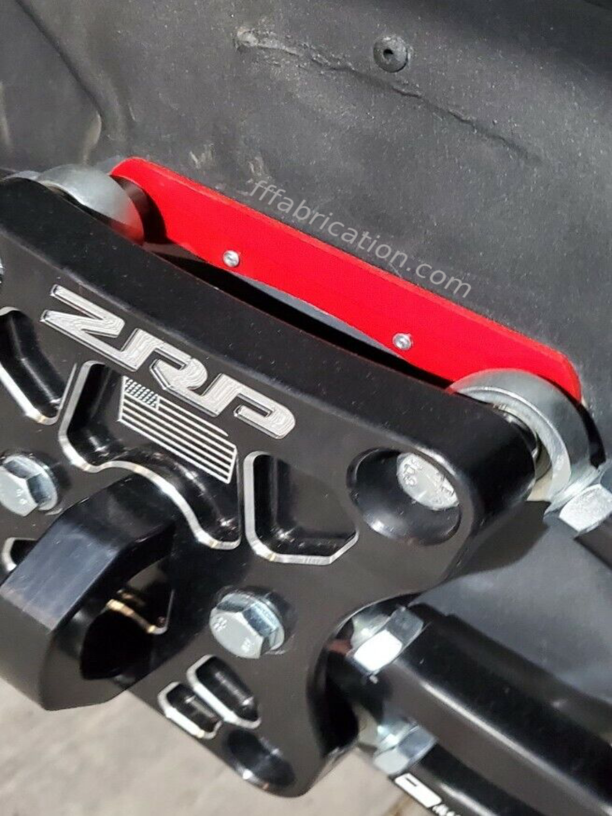 Close-up of a ZRP metal bracket with red accents on a vehicle's interior.