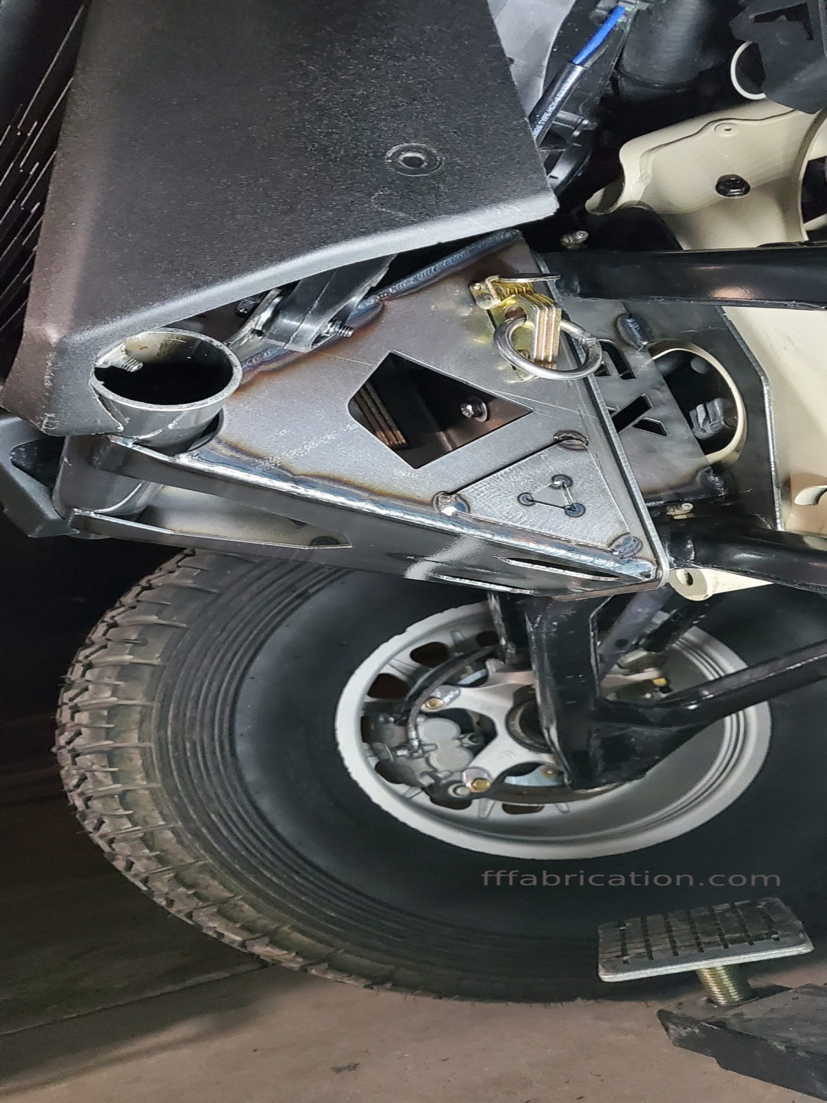 Close-up of a vehicle's undercarriage with visible suspension components and tire.