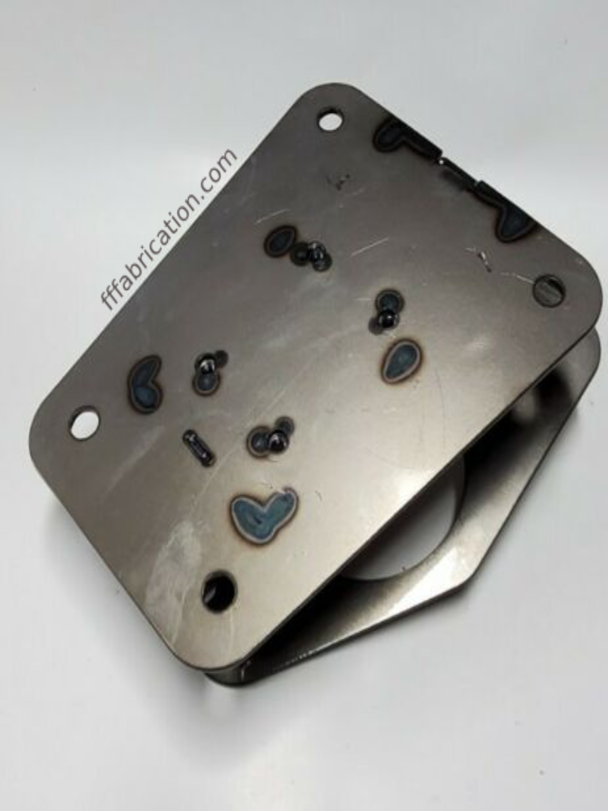 Metal component with a heart-shaped logo on a white background
