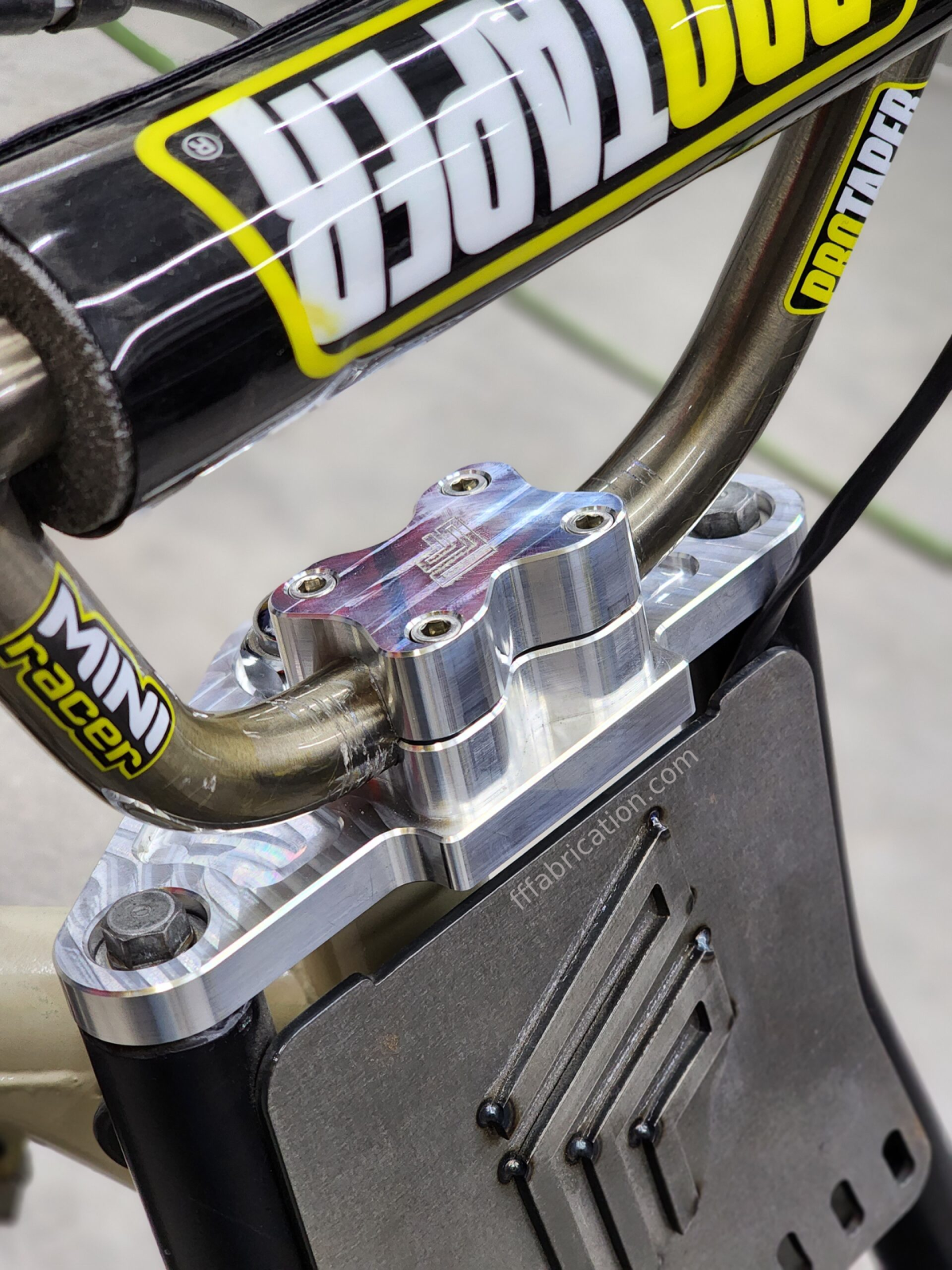 Close-up of a motorcycle suspension system with 'Mini Racer' branding.
