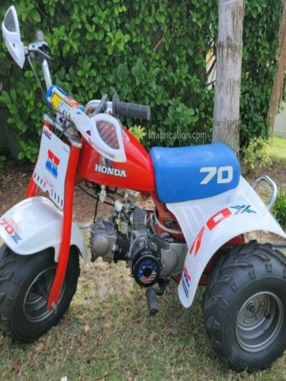 Honda mini bike with '70' on the seat, parked outdoors.